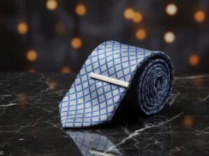 Rolled blue tie on marble surface